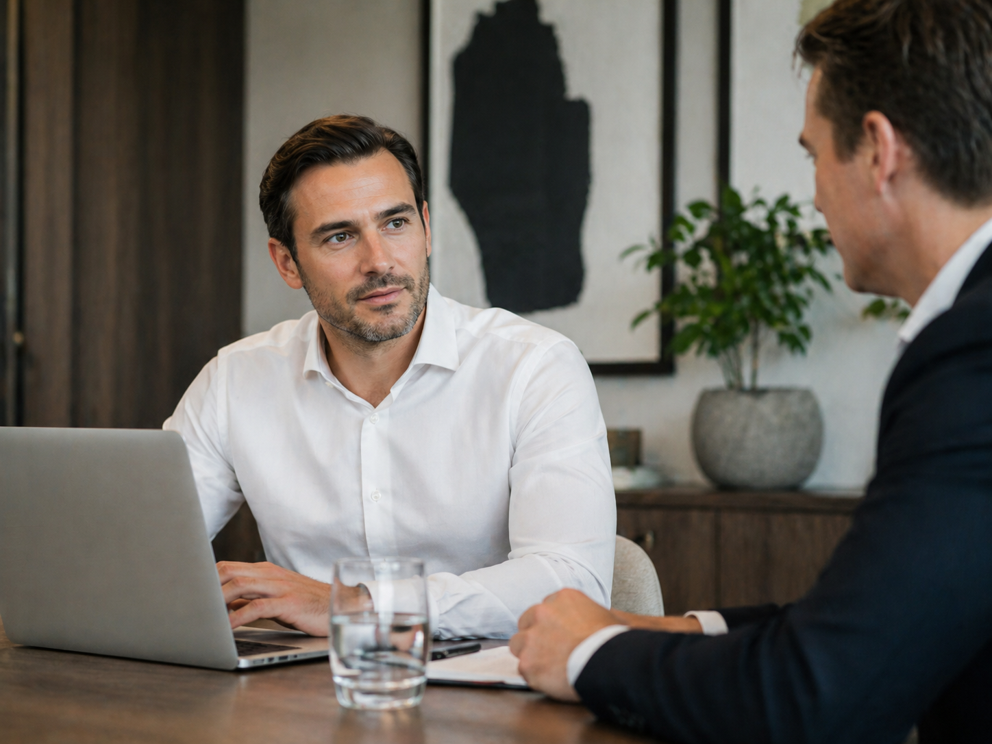 Two professionals discussing portfolio management in a modern office